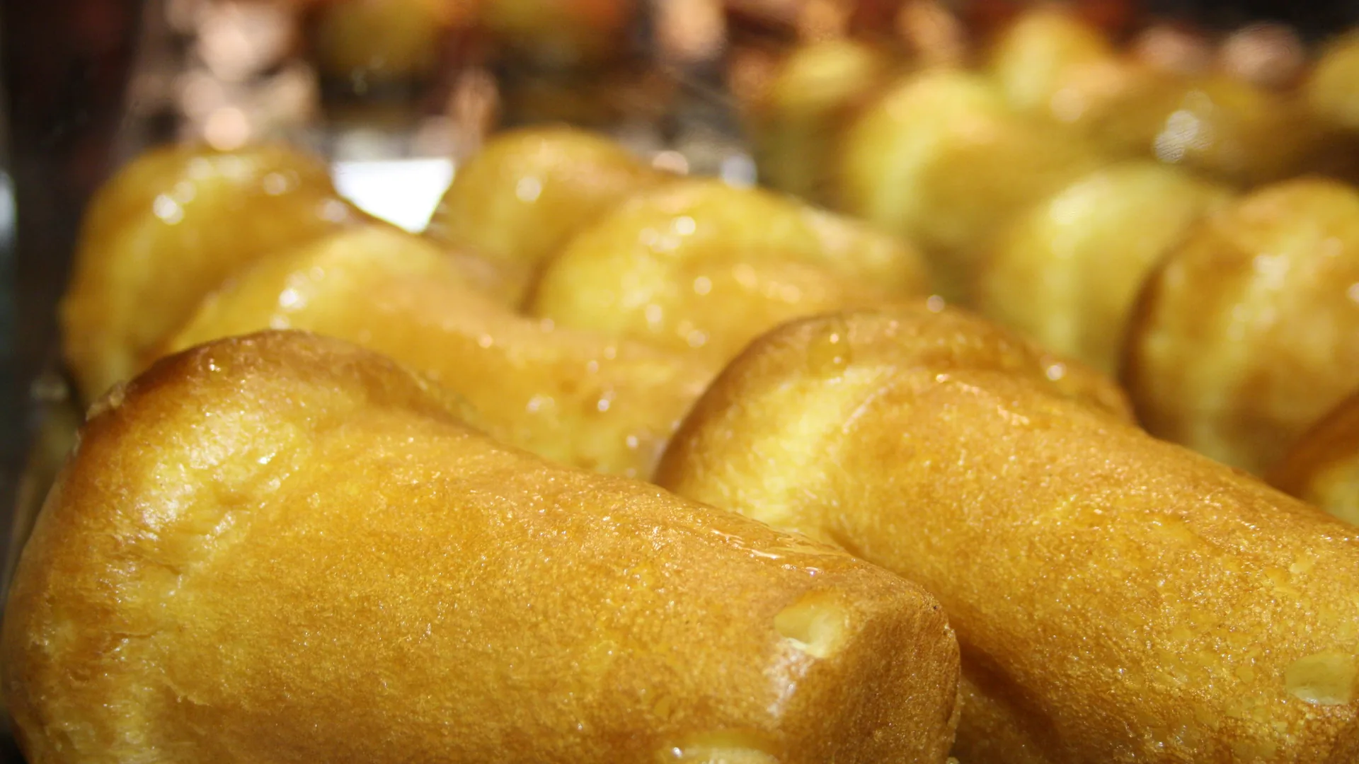 Close-up of golden rum babà cakes on a pastry counter, from the Naples by Night food and wine tour listing